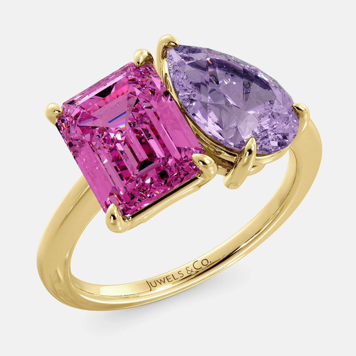 A toi et moi ring with an emerald-cut Pink Sapphire and pear-cut gemstone. The emerald-cut is set on the left of the ring, and the pear-cut gemstone is set on the right. The ring is made of recycled yellow gold and has a simple, elegant design. The pear-cut gemstone can be customized. **Here are some additional details about the image:** * The emerald-cut white Pink Sapphire is a birthstone for October. * The pear-cut gemstone can be customized to any stone of your choice.