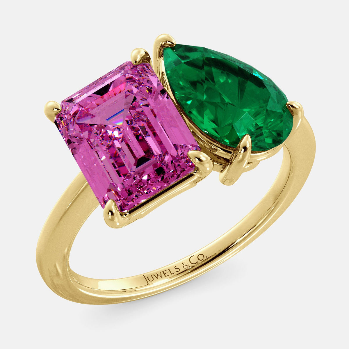A toi et moi ring with an emerald-cut Pink Sapphire and pear-cut gemstone. The emerald-cut is set on the left of the ring, and the pear-cut gemstone is set on the right. The ring is made of recycled yellow gold and has a simple, elegant design. The pear-cut gemstone can be customized. **Here are some additional details about the image:** * The emerald-cut white Pink Sapphire is a birthstone for October. * The pear-cut gemstone can be customized to any stone of your choice.