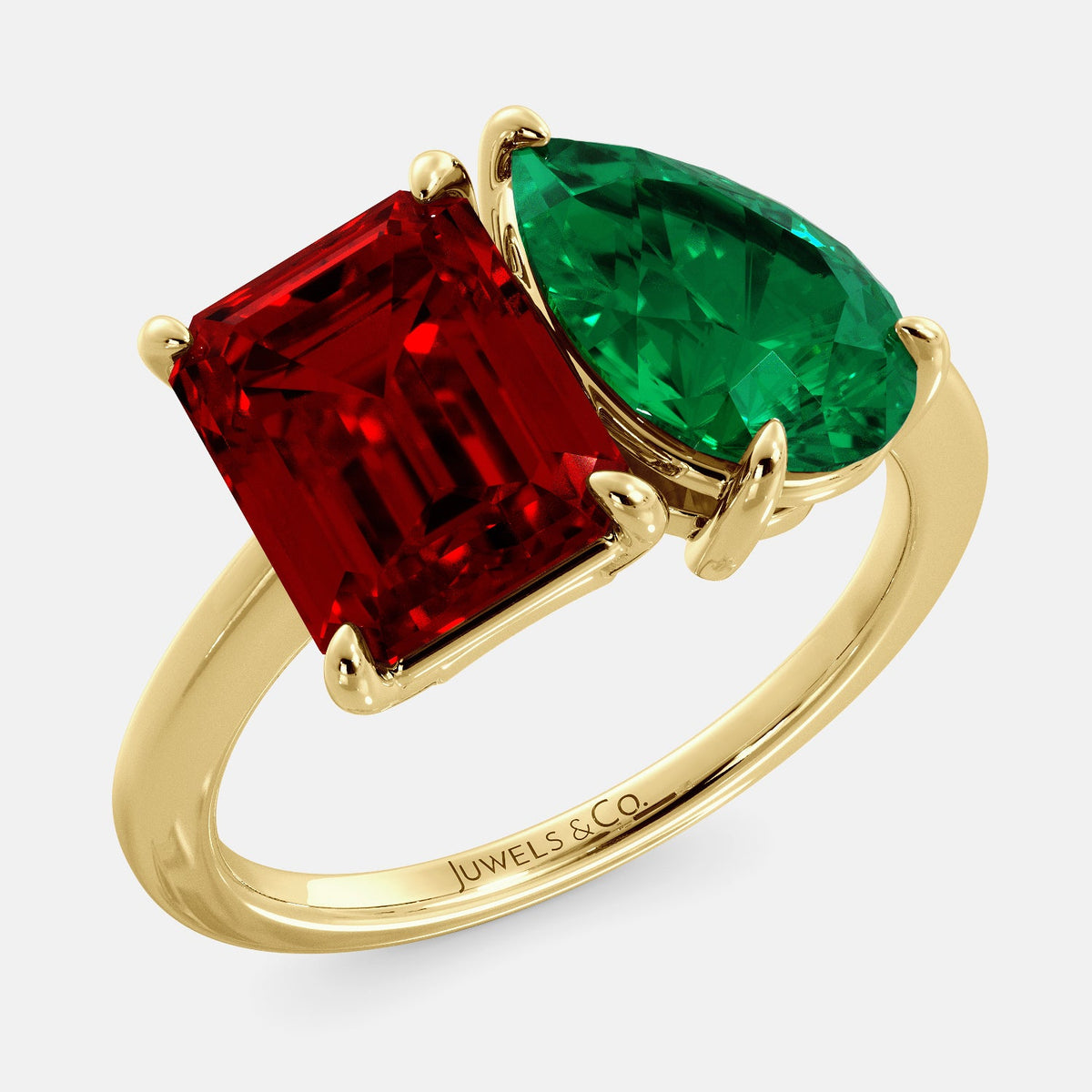 A toi et moi ring with an emerald-cut ruby and a pear-cut gemstone. The emerald-cut morganite is set on the left of the ring, and the pear-cut gemstone is set on the right. The ring is made of recycled yellow gold and has a simple, elegant design. The pear-cut gemstone can be customized. **Here are some additional details about the image:** * The emerald-cut white ruby is a birthstone for July. * The pear-cut gemstone can be customized to any stone of your choice.