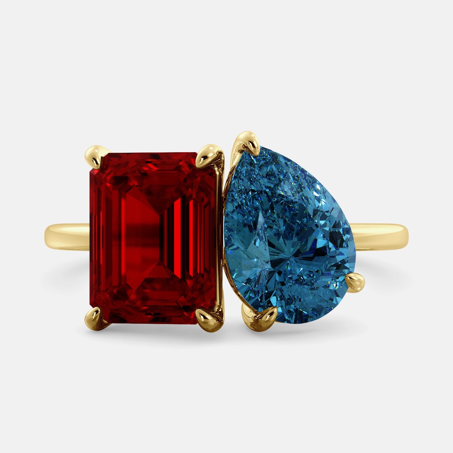 A toi et moi ring with an emerald-cut ruby and a pear-cut gemstone. The emerald-cut morganite is set on the left of the ring, and the pear-cut gemstone is set on the right. The ring is made of recycled yellow gold and has a simple, elegant design. The pear-cut gemstone can be customized. **Here are some additional details about the image:** * The emerald-cut white ruby is a birthstone for July. * The pear-cut gemstone can be customized to any stone of your choice.