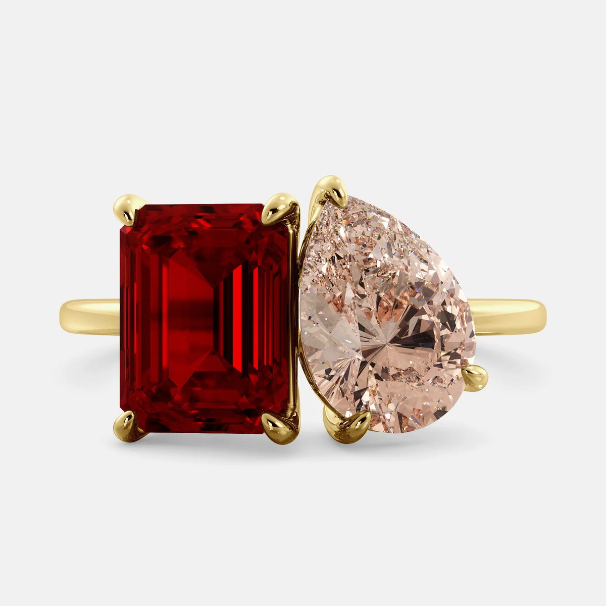 A toi et moi ring with a ruby stone in emerald cut and a pear-shaped stone. The ruby is a deep red color and the pear-shaped stone can be customized to represent the birth month stone of the wearer or a loved one. The ring is made of 14k gold and is available in all sizes. This ring is a perfect gift for any occasion, and it can be customized to make it truly unique.