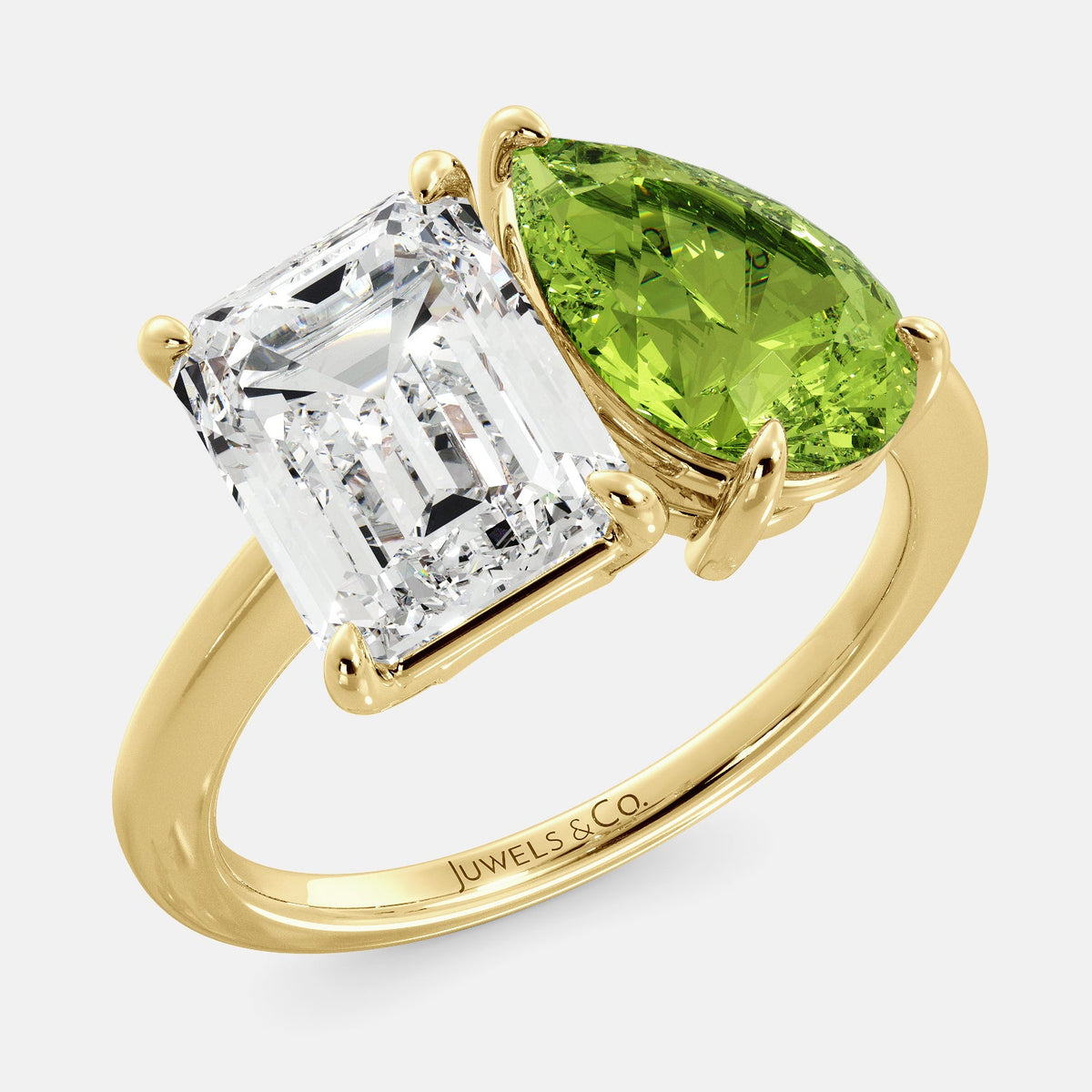 A toi et moi ring with an emerald-cut white topaz and a pear-cut gemstone. The emerald-cut morganite is set on the left of the ring, and the pear-cut gemstone is set on the right. The ring is made of recycled yellow gold and has a simple, elegant design. The pear-cut gemstone can be customized. **Here are some additional details about the image:** * The emerald-cut white topaz is a birthstone for April. * The pear-cut gemstone can be customized to any stone of your choice.