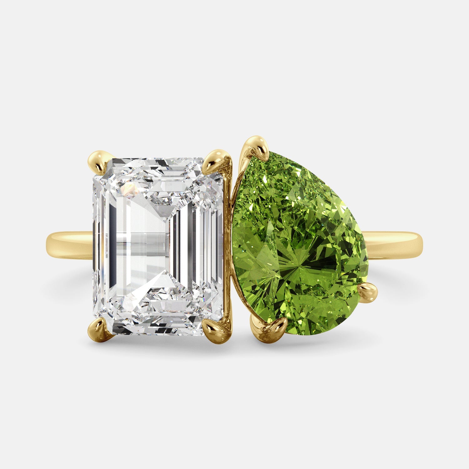 A toi et moi ring with an emerald-cut white topaz and a pear-cut gemstone. The emerald-cut morganite is set on the left of the ring, and the pear-cut gemstone is set on the right. The ring is made of recycled yellow gold and has a simple, elegant design. The pear-cut gemstone can be customized. **Here are some additional details about the image:** * The emerald-cut white topaz is a birthstone for April. * The pear-cut gemstone can be customized to any stone of your choice.