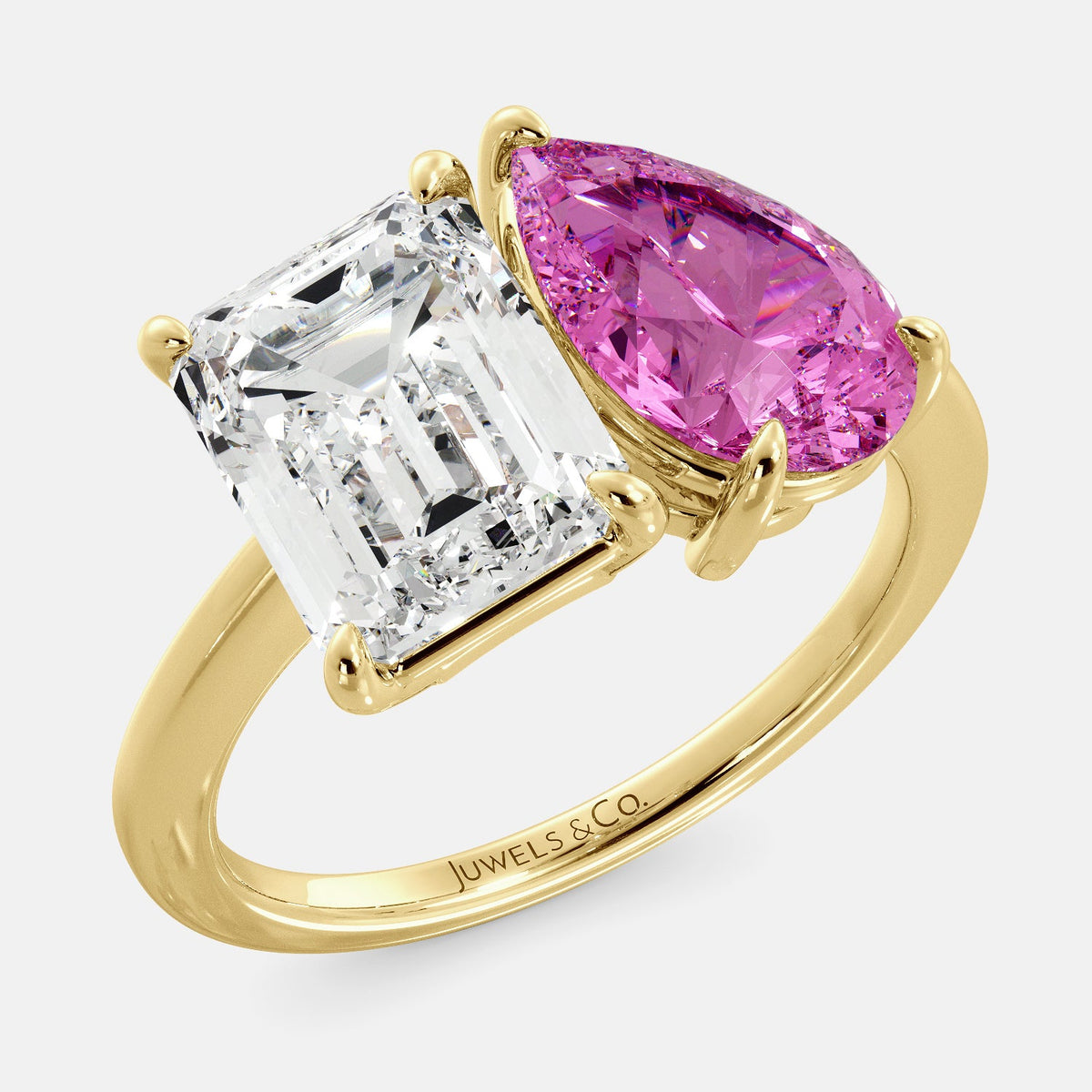 A toi et moi ring with an emerald-cut white topaz and a pear-cut gemstone. The emerald-cut morganite is set on the left of the ring, and the pear-cut gemstone is set on the right. The ring is made of recycled yellow gold and has a simple, elegant design. The pear-cut gemstone can be customized. **Here are some additional details about the image:** * The emerald-cut white topaz is a birthstone for April. * The pear-cut gemstone can be customized to any stone of your choice.