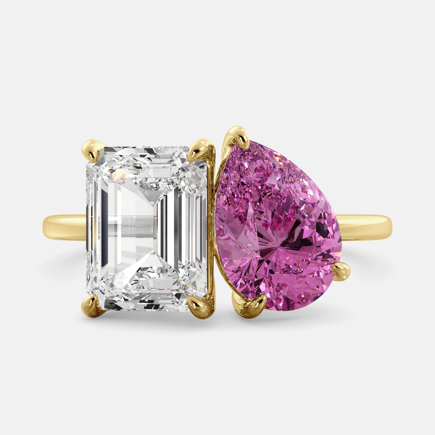 A toi et moi ring with an emerald-cut white topaz and a pear-cut gemstone. The emerald-cut morganite is set on the left of the ring, and the pear-cut gemstone is set on the right. The ring is made of recycled yellow gold and has a simple, elegant design. The pear-cut gemstone can be customized. **Here are some additional details about the image:** * The emerald-cut white topaz is a birthstone for April. * The pear-cut gemstone can be customized to any stone of your choice.
