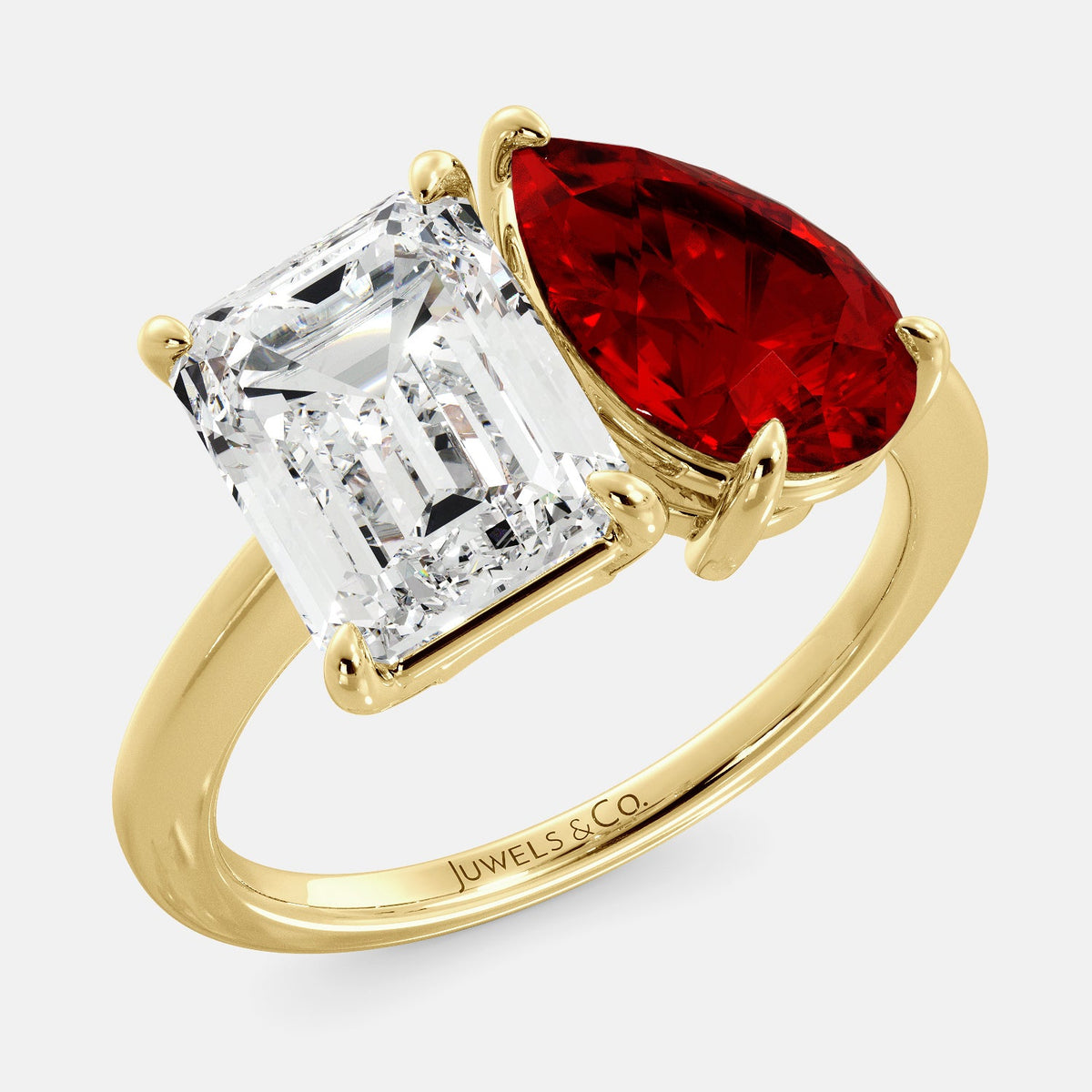 A toi et moi ring with an emerald-cut white topaz and a pear-cut gemstone. The emerald-cut morganite is set on the left of the ring, and the pear-cut gemstone is set on the right. The ring is made of recycled yellow gold and has a simple, elegant design. The pear-cut gemstone can be customized. **Here are some additional details about the image:** * The emerald-cut white topaz is a birthstone for April. * The pear-cut gemstone can be customized to any stone of your choice.
