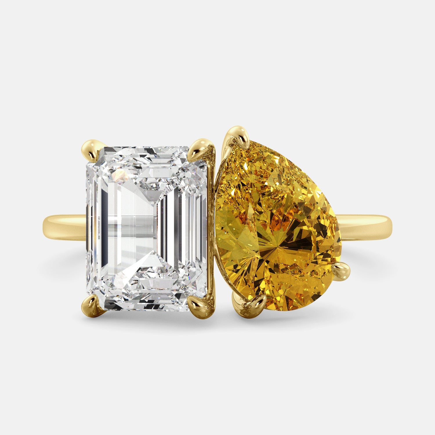 A toi et moi ring with an emerald-cut white topaz and a pear-cut gemstone. The emerald-cut morganite is set on the left of the ring, and the pear-cut gemstone is set on the right. The ring is made of recycled yellow gold and has a simple, elegant design. The pear-cut gemstone can be customized. **Here are some additional details about the image:** * The emerald-cut white topaz is a birthstone for April. * The pear-cut gemstone can be customized to any stone of your choice.