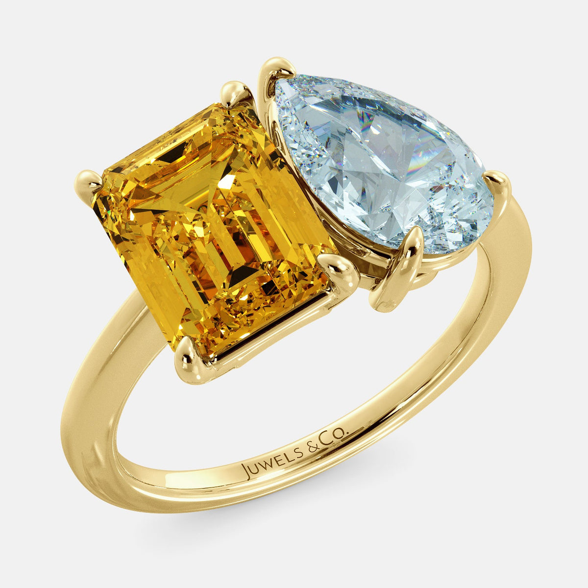 A toi et moi ring with an emerald-cut Citrin and pear-cut gemstone. The emerald-cut morganite is set on the left of the ring, and the pear-cut gemstone is set on the right. The ring is made of recycled yellow gold and has a simple, elegant design. The pear-cut gemstone can be customized. **Here are some additional details about the image:** * The emerald-cut white Citrin is a birthstone for November. * The pear-cut gemstone can be customized to any stone of your choice.