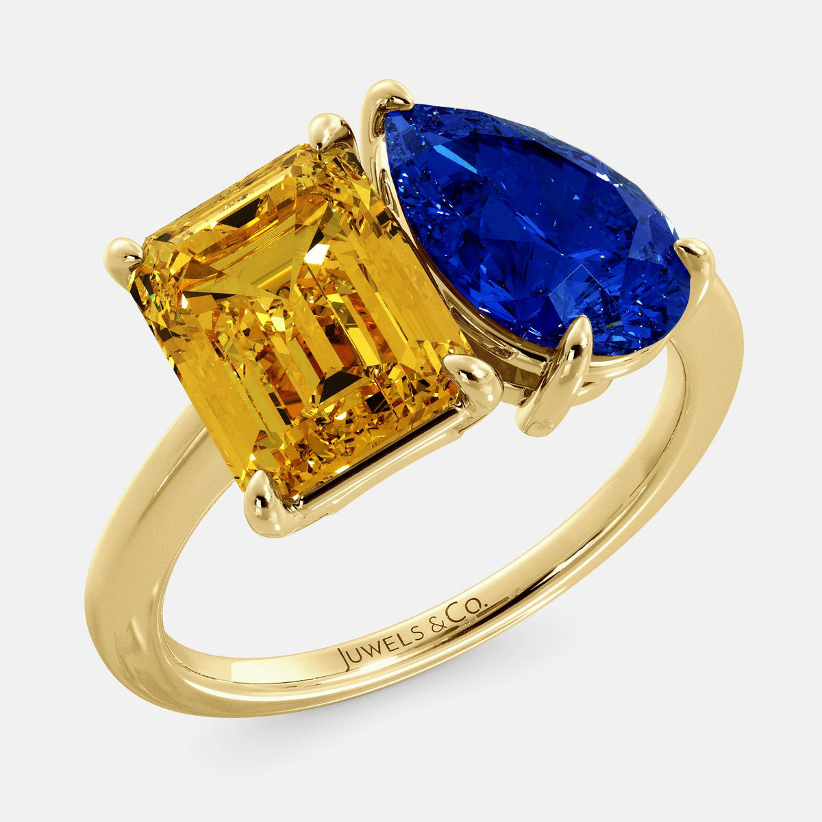 A toi et moi ring with an emerald-cut Citrin and pear-cut gemstone. The emerald-cut morganite is set on the left of the ring, and the pear-cut gemstone is set on the right. The ring is made of recycled yellow gold and has a simple, elegant design. The pear-cut gemstone can be customized. **Here are some additional details about the image:** * The emerald-cut white Citrin is a birthstone for November. * The pear-cut gemstone can be customized to any stone of your choice.