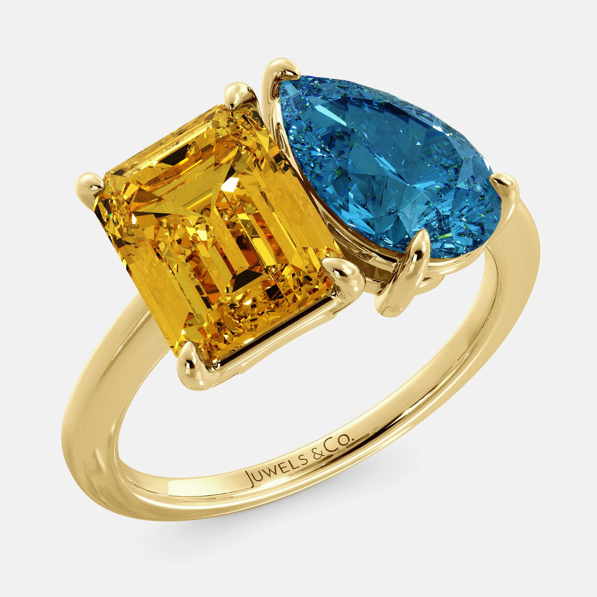 A toi et moi ring with an emerald-cut Citrin and pear-cut gemstone. The emerald-cut morganite is set on the left of the ring, and the pear-cut gemstone is set on the right. The ring is made of recycled yellow gold and has a simple, elegant design. The pear-cut gemstone can be customized. **Here are some additional details about the image:** * The emerald-cut white Citrin is a birthstone for November. * The pear-cut gemstone can be customized to any stone of your choice.