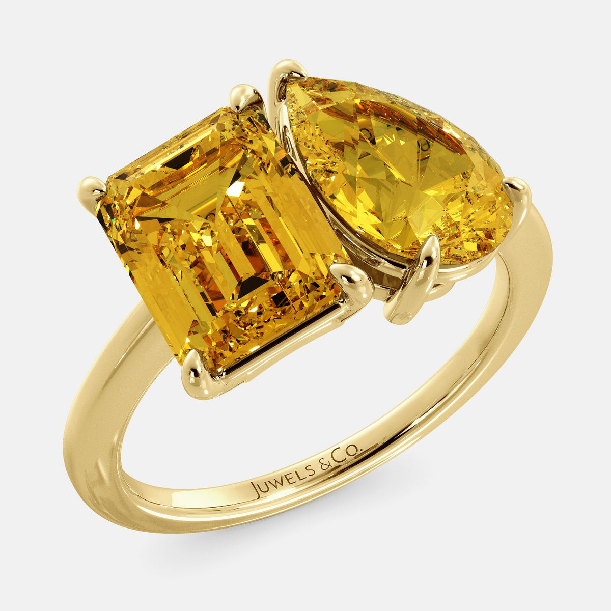 A toi et moi ring with an emerald-cut Citrin and pear-cut gemstone. The emerald-cut morganite is set on the left of the ring, and the pear-cut gemstone is set on the right. The ring is made of recycled yellow gold and has a simple, elegant design. The pear-cut gemstone can be customized. **Here are some additional details about the image:** * The emerald-cut white Citrin is a birthstone for November. * The pear-cut gemstone can be customized to any stone of your choice.